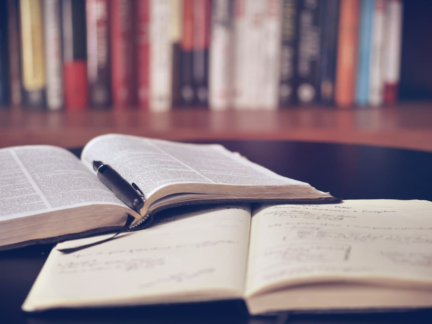 Livro aberto e caderno de anotações — estudo focado, sem ruído